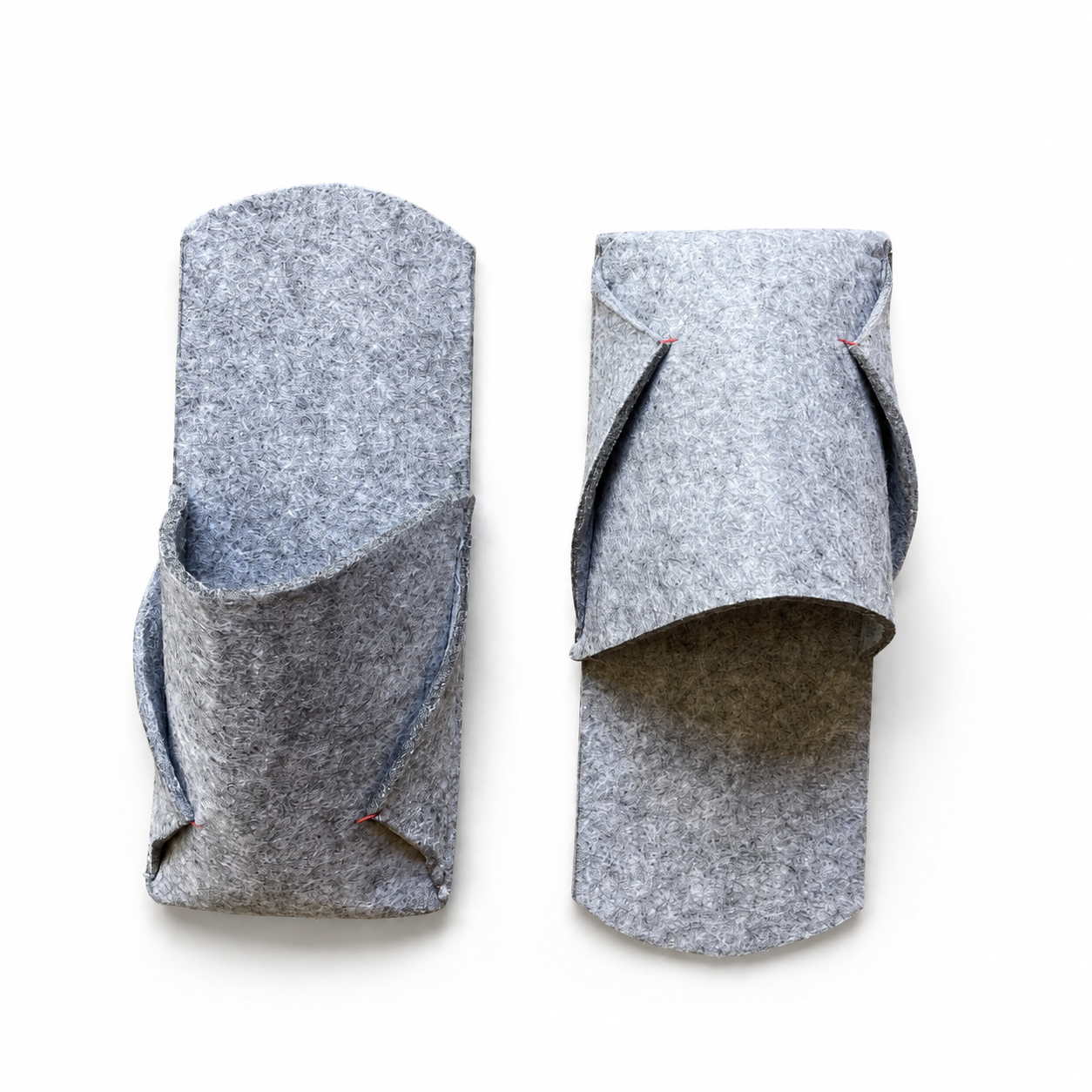 Top view of a pair of grey felted wool BAABUK slippers showing the envelope construction and red thread details